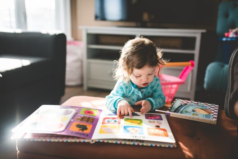 A parent and young child sitting together on a colorful rug, talking calmly while playing with building blocks.