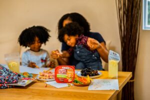 Young children sharing toys and playing together in a bright, well-lit room.
