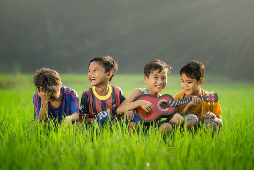 Young children singing and playing with simple hand instruments together in a colorful classroom.