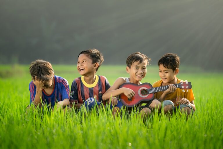 Young children singing and playing with simple hand instruments together in a colorful classroom.