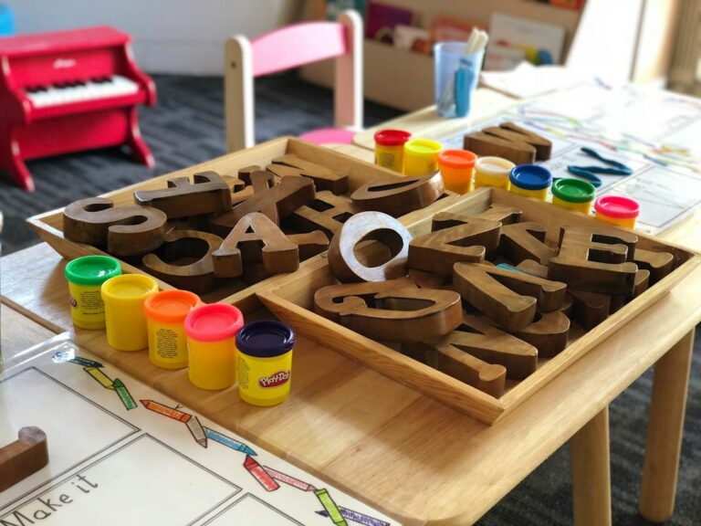Child and adult sort colorful blocks by shape and count them on a playroom floor.